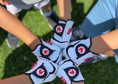 Junior golfers showing donated golf gloves for a youth golf program